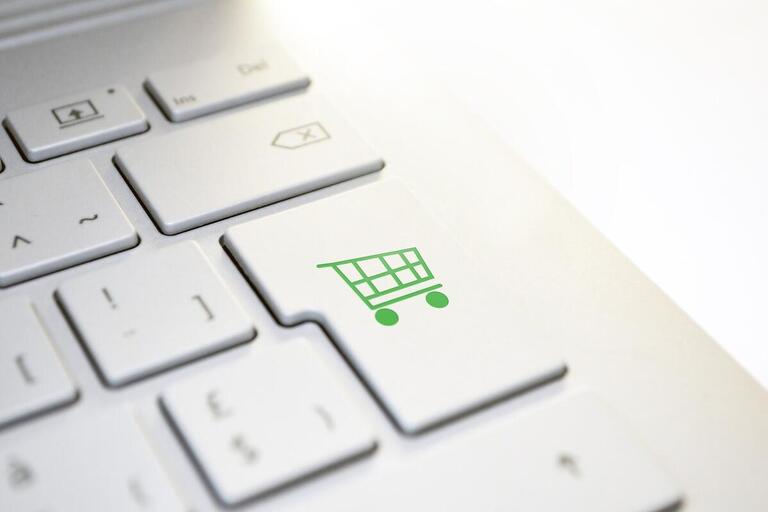 A keyboard with a button with a green shopping cart icon on it