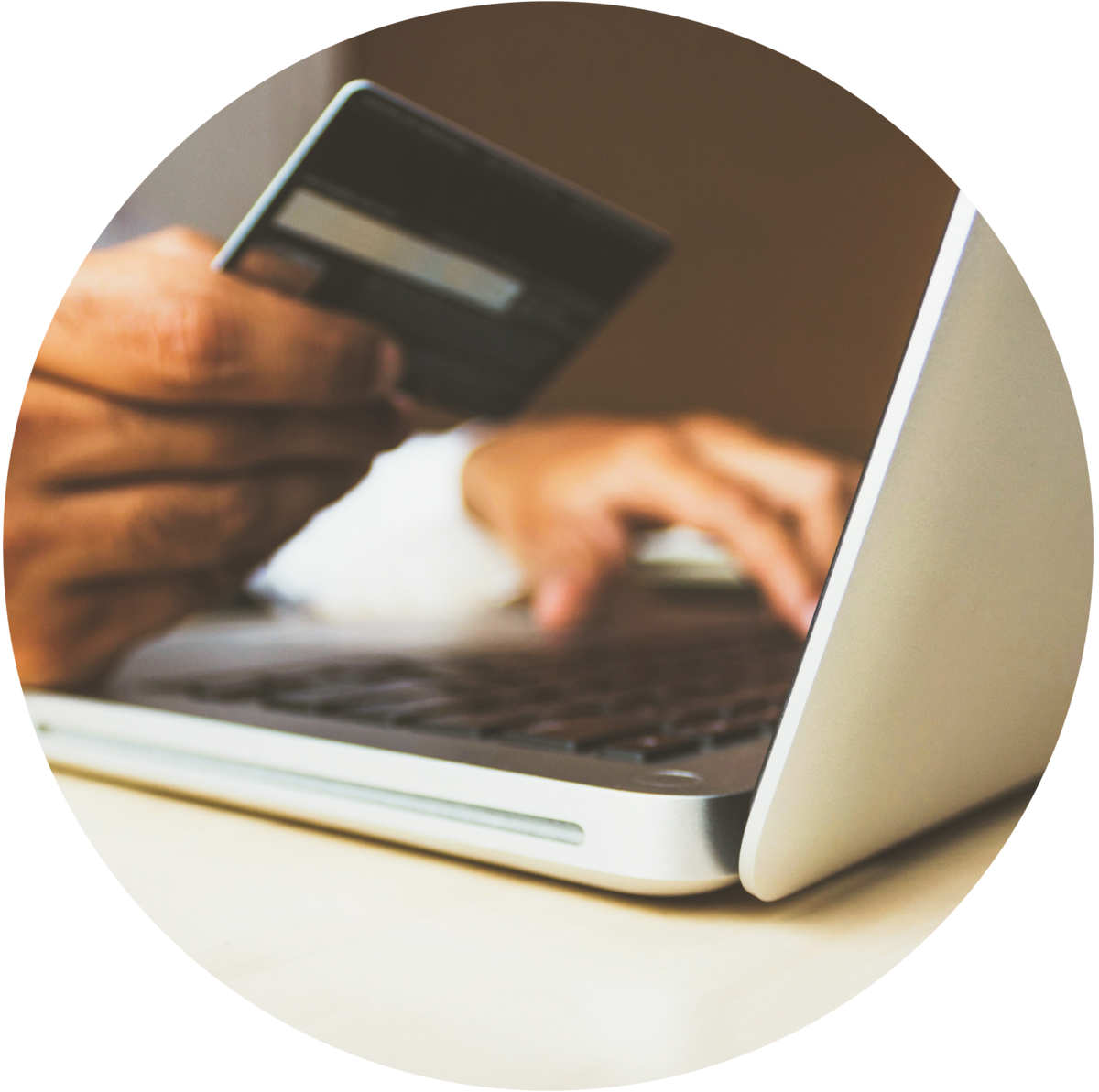 Hand holding a credit card over a laptop keyboard