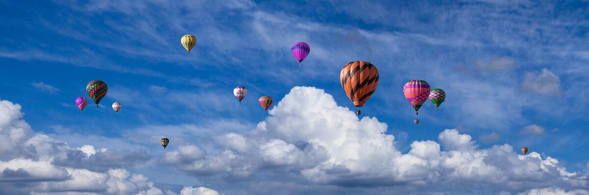 Colorful hot air balloons in cloudy sky