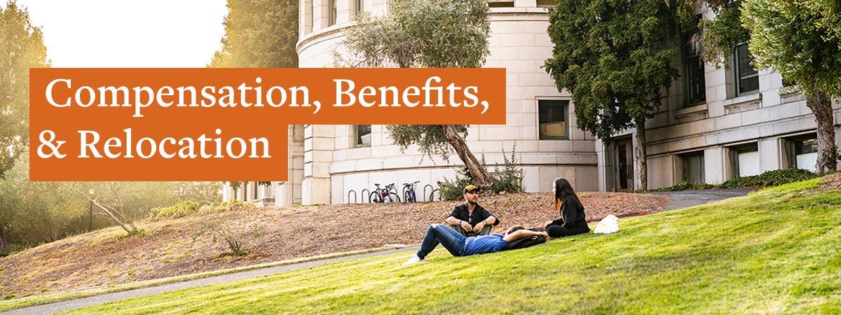 Three friends sit on the grass in the setting sun outside a UC Berkeley building. 