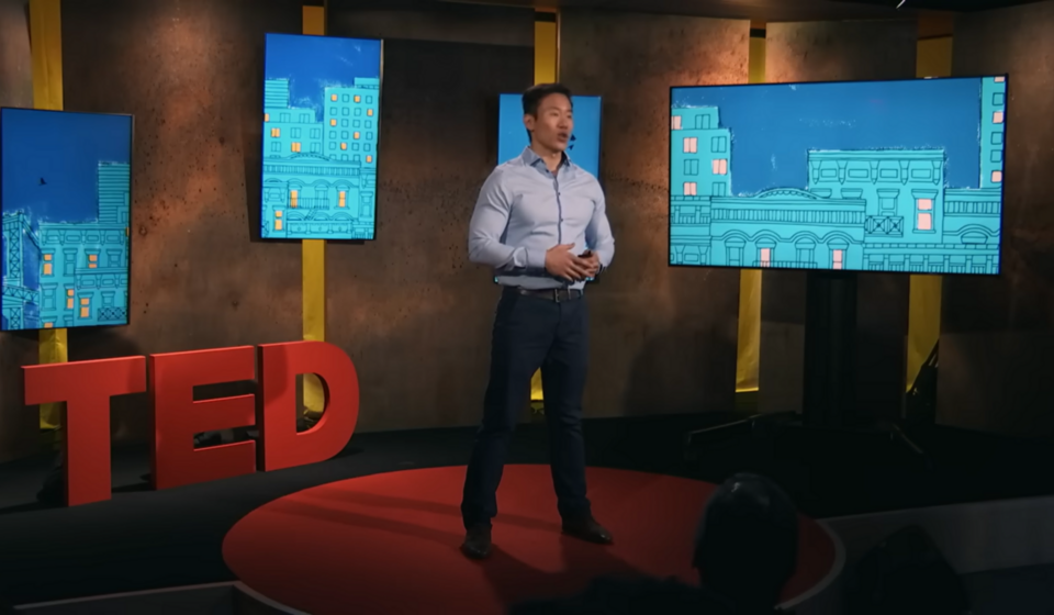 Image of Jason Shen speaking on stage with the TED logo by his side