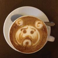 Coffee mug with latte art of a bear.