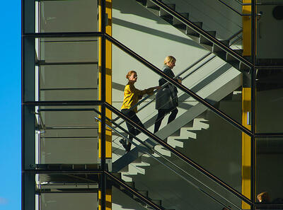 Two people climbing a staircase. 